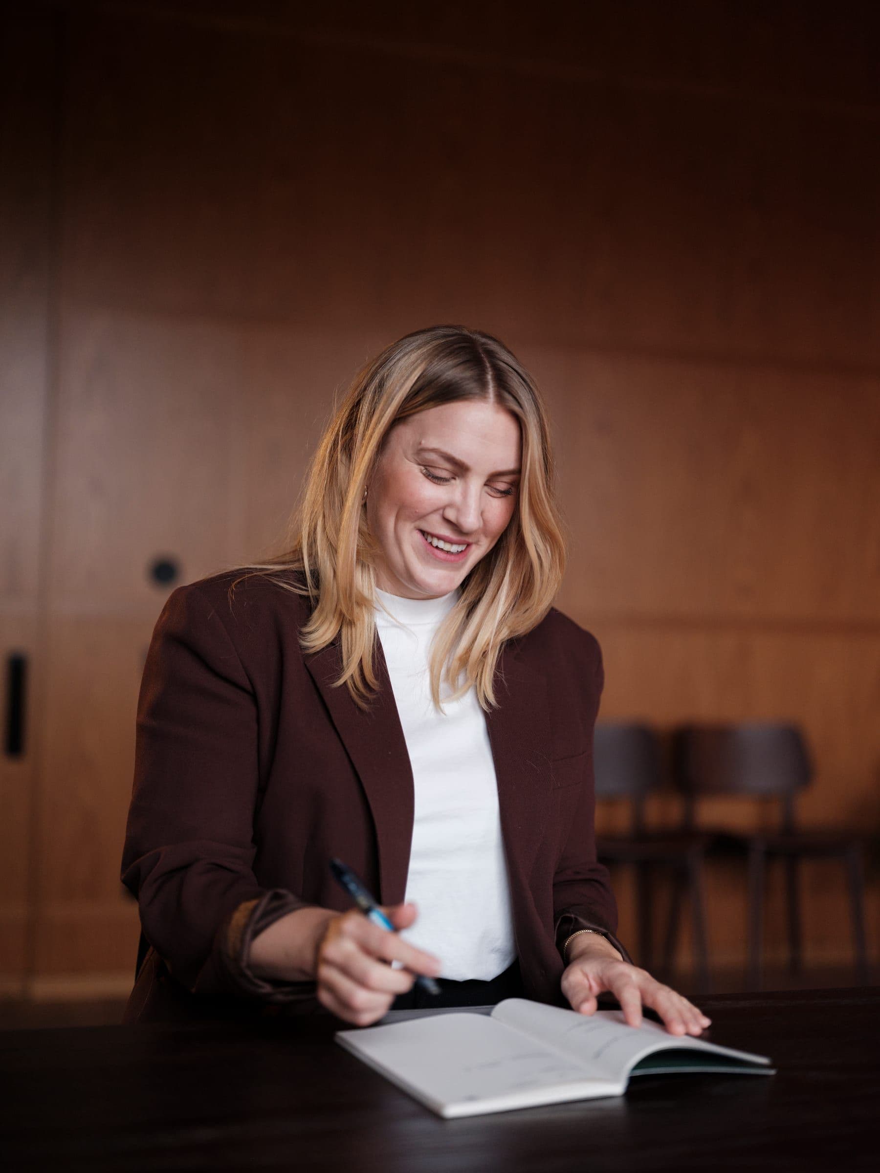 A Curamando consultant writing in a notebook at a meeting table